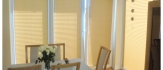 Eleganckie plisy materiałowe na oknach tarasowych: Nowoczesny akcent i ochrona przed słońcem.